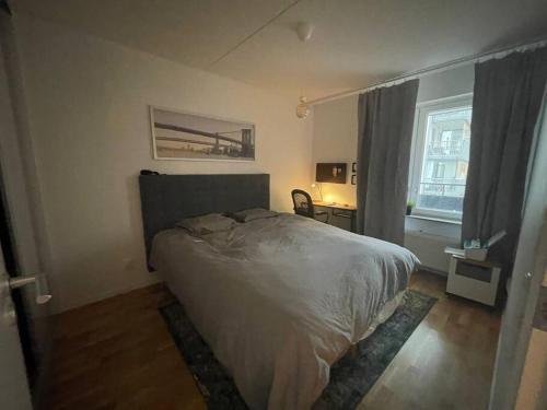 1 dormitorio con cama, escritorio y ventana en Modern & New Apartment Near CenterUniHospital With Balcony, en Uppsala