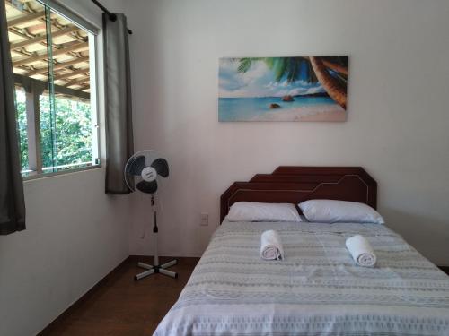een slaapkamer met een bed, een ventilator en een raam bij Estadia cipó in Serra do Cipo