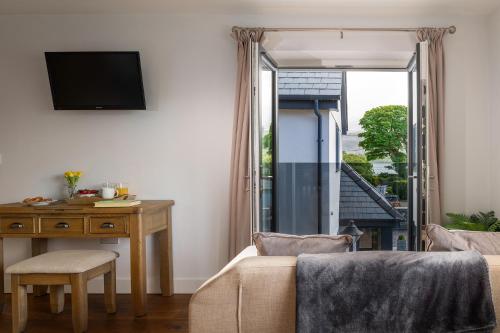 a living room with a bed and a desk and a window at Arlyn, Padarn Lake Viewpoint in Snowdonia in Caernarfon