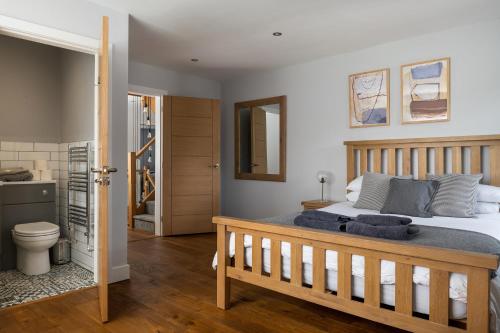 a bedroom with a bed and a bathroom at Arlyn, Padarn Lake Viewpoint in Snowdonia in Caernarfon