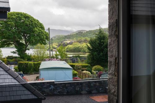a view of a garden from the window of a house at Arlyn, Padarn Lake Viewpoint in Snowdonia in Caernarfon