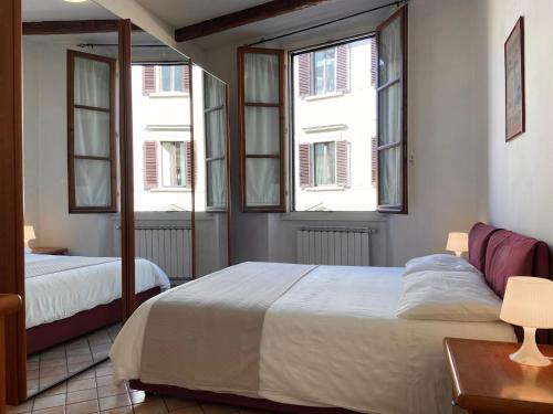 una camera con due letti e due finestre di Appartamento caratteristico Santa Maria Novella a Firenze