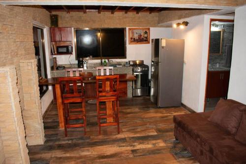 a kitchen with a refrigerator and a table and chairs at Juliet's Coffee House in Higueronal