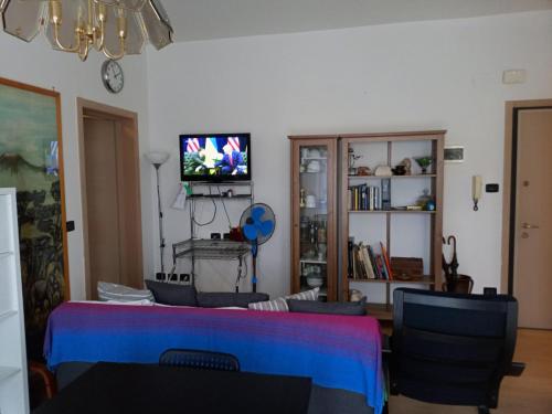 a living room with a table and chairs and a tv at BOLOGNA QUARTIERE SAVENA - APPARTAMENTO DI STEFANO in Bologna