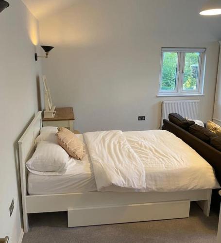 a white bed in a bedroom with a window at The Lodge in Royal Tunbridge Wells