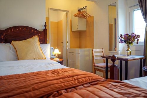 una camera con letto, scrivania e tavolo di Residencial Airside Palace a Lisbona