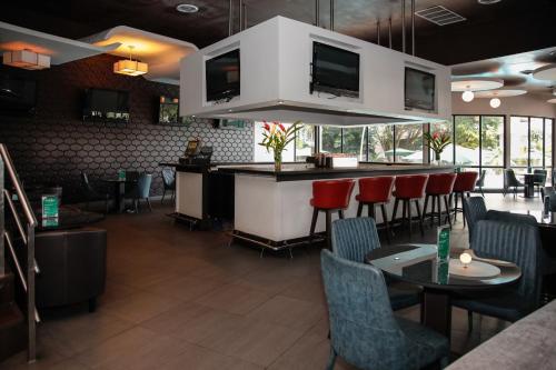 a restaurant with a bar with chairs and tables at Plaza Paitilla Inn in Panama City