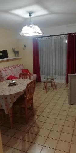 un salon avec une table et une salle à manger dans l'établissement Les Dryades L'Epicéa, à Gérardmer