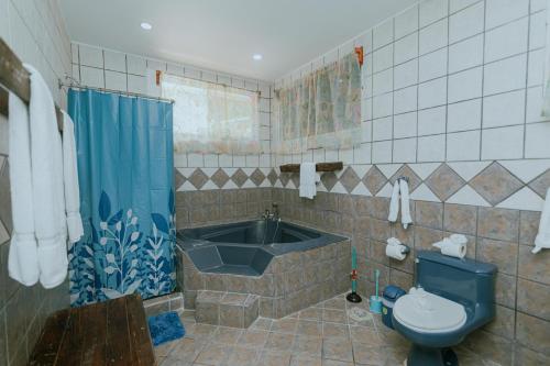 ein Badezimmer mit einer Badewanne, einem WC und einem Waschbecken in der Unterkunft Oasis Diverse Adult Retreat in Quepos