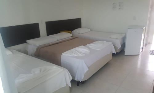 Łóżko lub łóżka w pokoju w obiekcie Pousada Peruíbe Ametista