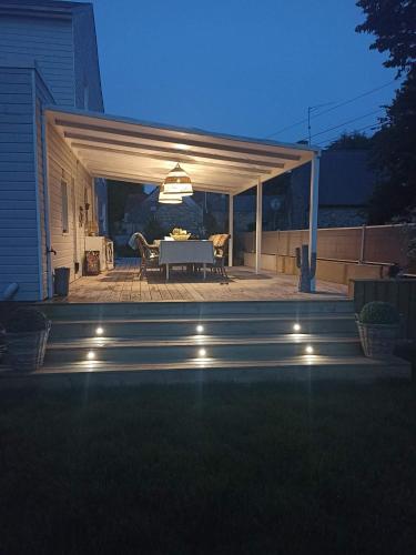 a patio with a white table and a dining room at lodge avec vue sur la rivière in Lannion