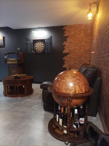 a room with a couch and a table with bottles of wine at Chambre d'hôte avec Hammam et salle de jeux in Chazelles-sur-Lyon
