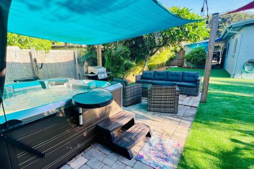 a patio with a table and a blue umbrella at Luxury 2/2 private oasis w/Hot Tub walk to Beach in Cape Canaveral