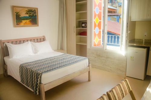 a bedroom with a bed and a window in a room at Pousada e Hostel Chez Marianne in Salvador