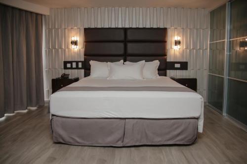 a bedroom with a large bed with a black headboard at Plaza Paitilla Inn in Panama City