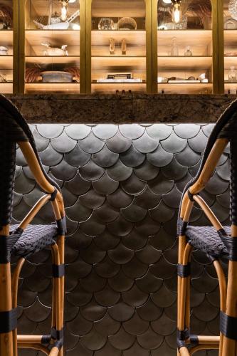 a kitchen with a counter with two chairs in front of a table at Tau House in Guatapé