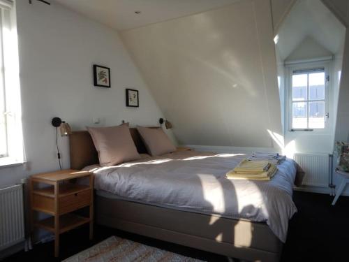 - une chambre avec un lit dans l'établissement Comfortabel en gezellig vakantiehuis bij het strand, à Wemeldinge