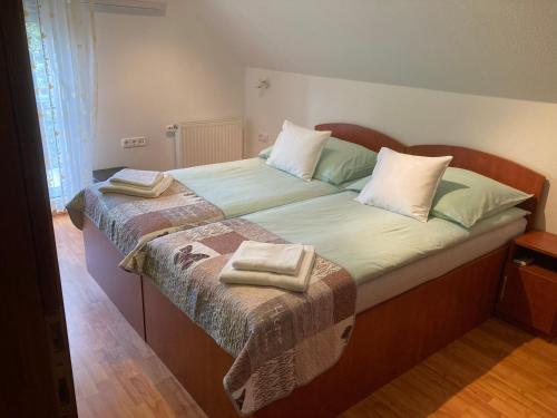a bedroom with a large bed with two towels on it at Príma Vendégház in Tiszakécske