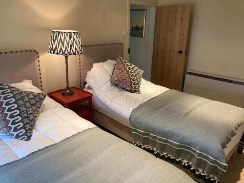 two beds sitting next to each other in a room at Pretty Yorkshire Stone Cottage Harome in Harome