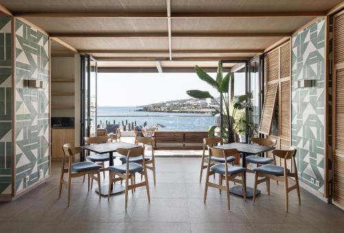 a dining room with tables and chairs and a view of the ocean at Eden Roc Resort - All Inclusive in Kallithea Rhodes