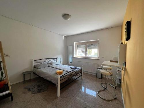 een slaapkamer met een bed, een bureau en een raam bij BED AND BREAKFAST SWALLOW in Trzin