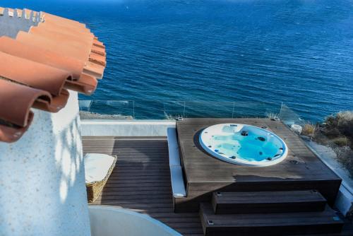 a bath tub sitting on a deck next to the water at DELFIN Luxury Villa Water Front Jacuzzi in Águilas