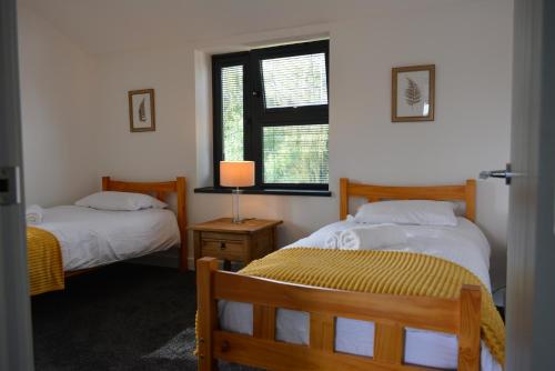 a bedroom with two beds and a window at 8 Jarn Court in Oxford