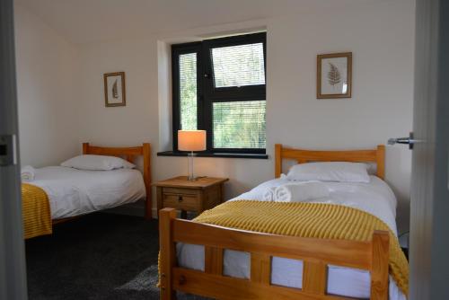 a bedroom with two beds and a window at Lovely & Spacious 2-Bedroom Apartment with Balcony and Free Parking in Oxford