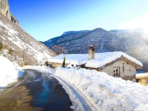 a house covered in snow next to a road at Gîte L'Echappée en Vercors - Observatoire des étoiles in Choranche