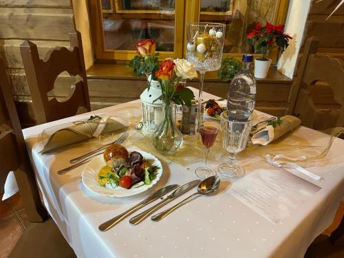 a white table with a plate of food on it at Slanický Dvor in Námestovo