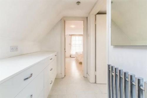 a white kitchen with white cabinets and a staircase at Beautiful apartment in the heart of Rochester in Rochester