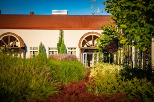a building with a garden in front of it at Santa Natura Resort & SPA in Nowa Wieś