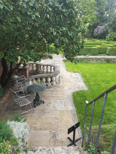 a patio with a bench and a table in a garden at Beautiful apartment in the heart of Rochester in Rochester
