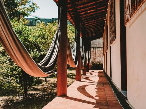 a hammock on a porch of a house at Nirvana Pipa in Pipa