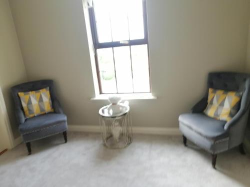 two chairs and a table in a room with a window at Clonoughter Heights in Glin
