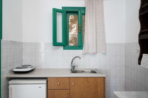 a kitchen with a sink and a window at TA PLAGIA accommodation in Anafi