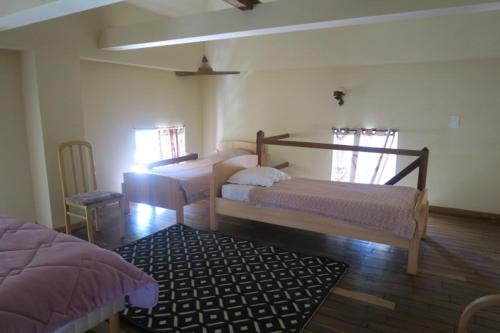 a bedroom with two beds and a rug in it at Colombier du château in Vitry-la-Ville