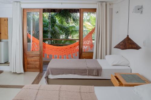 a bedroom with two beds and a balcony at Pousada Chez Toi in Jericoacoara