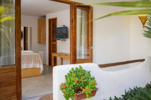 a living room with a white couch and a plant at Pousada Chez Toi in Jericoacoara