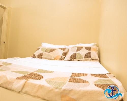 Una cama con almohadas y un edredón. en Mariner Motel, en Bridgetown