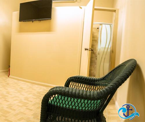 a black chair sitting in a room with a television at Mariner Motel in Bridgetown