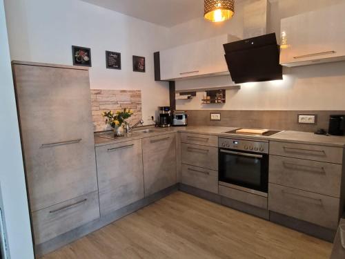 a kitchen with stainless steel cabinets and a stove at Ferienwohnung Holzland in Bad Klosterlausnitz