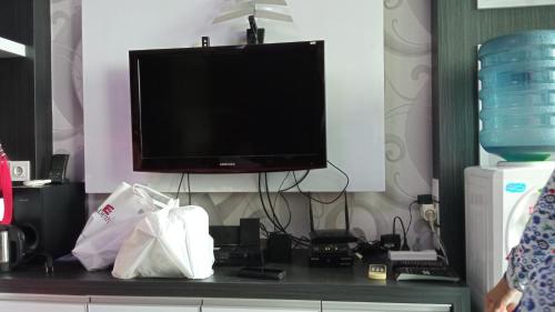 einen Fernseher auf einem Schreibtisch mit Taschen in der Unterkunft Aliston Papilio Apartment in Ngawinan