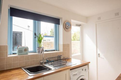 a kitchen with a sink and a window at Seashells, close to seafront, large private garden in Lyme Regis