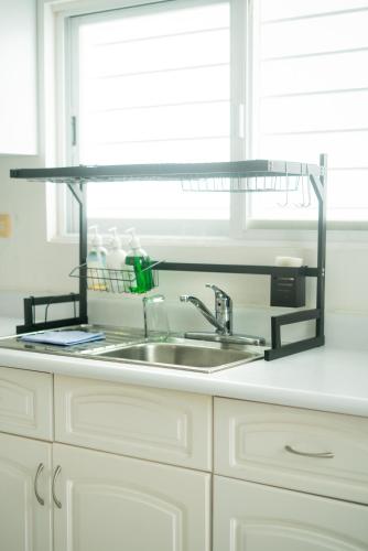 a kitchen sink with a metal shelf above it at Casa Familiar para hospedaje privado en Mérida in Mérida