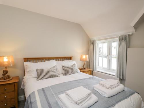a bedroom with a large bed with towels on it at Fisherbridge Cottage in Weymouth