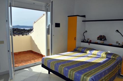 a bedroom with a bed and a sliding glass door at Hotel Nido D'aquila in La Maddalena