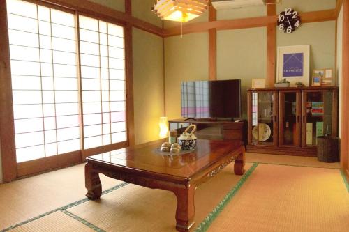 IKI HOUSE KATSUMOTOURA - Vacation STAY 13495v في إكي: غرفة معيشة مع طاولة قهوة وتلفزيون