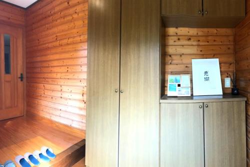 een keuken met houten wanden en houten vloeren en kasten bij IKI HOUSE KATSUMOTOURA - Vacation STAY 13495v in Iki