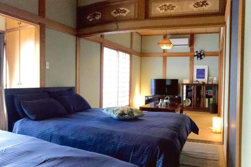 sypialnia z łóżkiem z niebieską kołdrą w obiekcie IKI HOUSE KATSUMOTOURA - Vacation STAY 13495v w Iki
